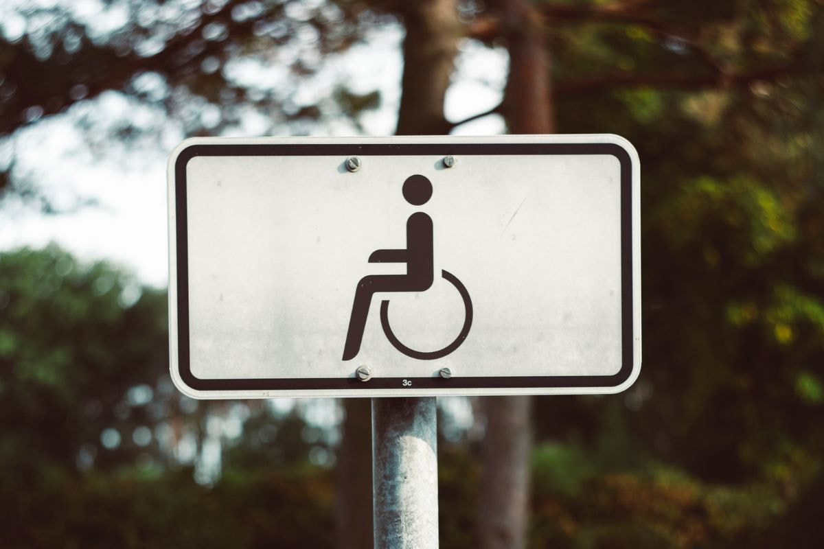 The universal symbol for Accessibility on a black and white signpost