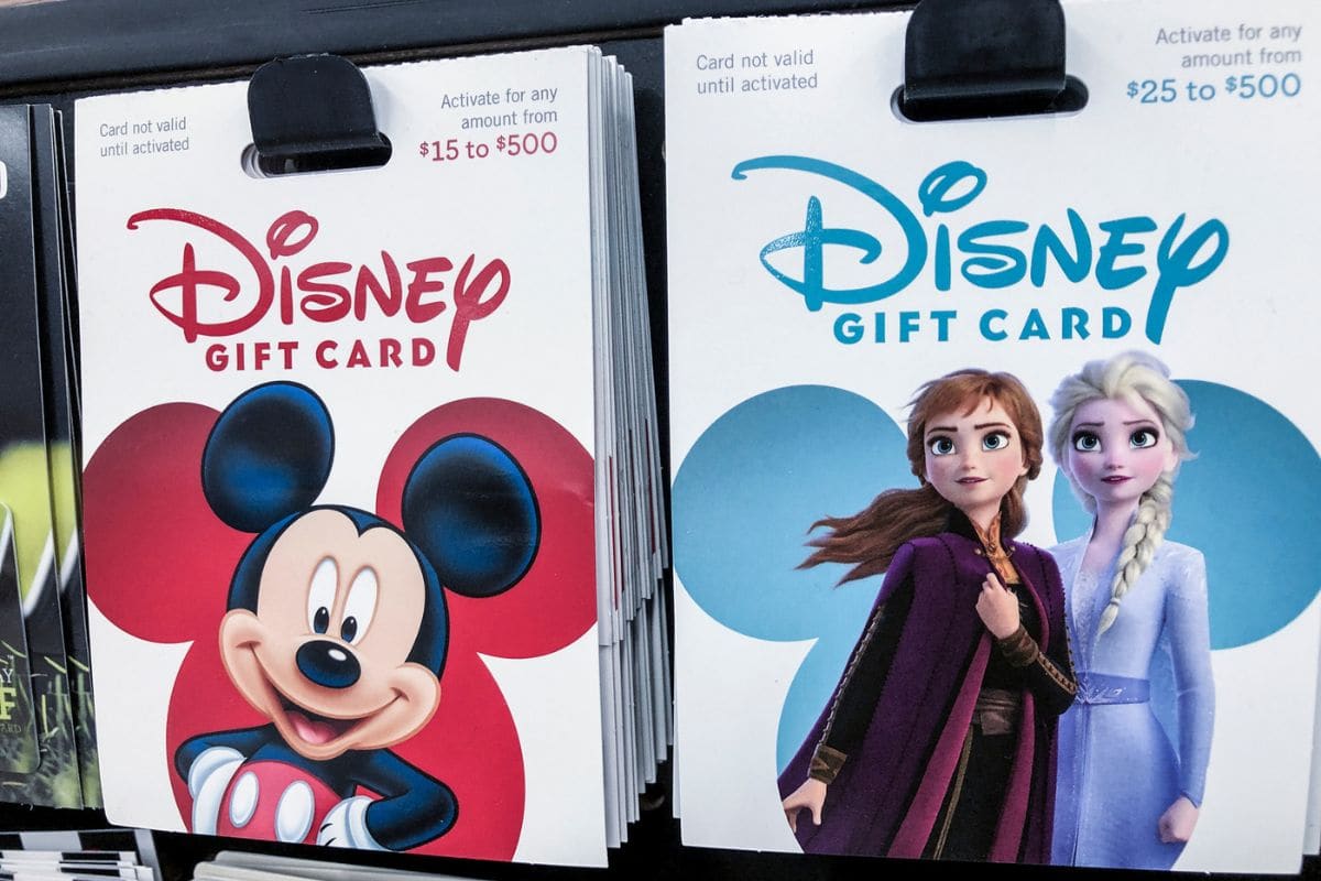 Multiple Disney Gift Cards displayed for sale on a rack
