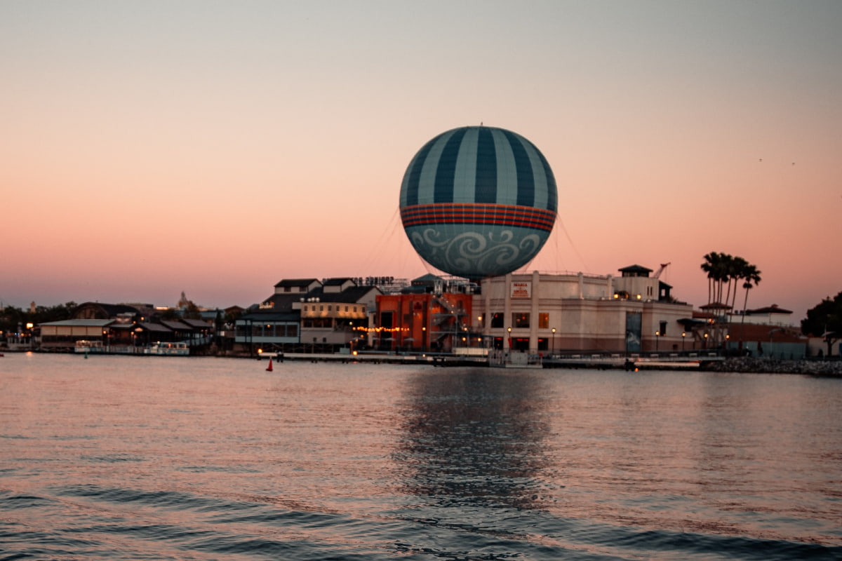 View from a distance across the water of Disney Springs during sunset