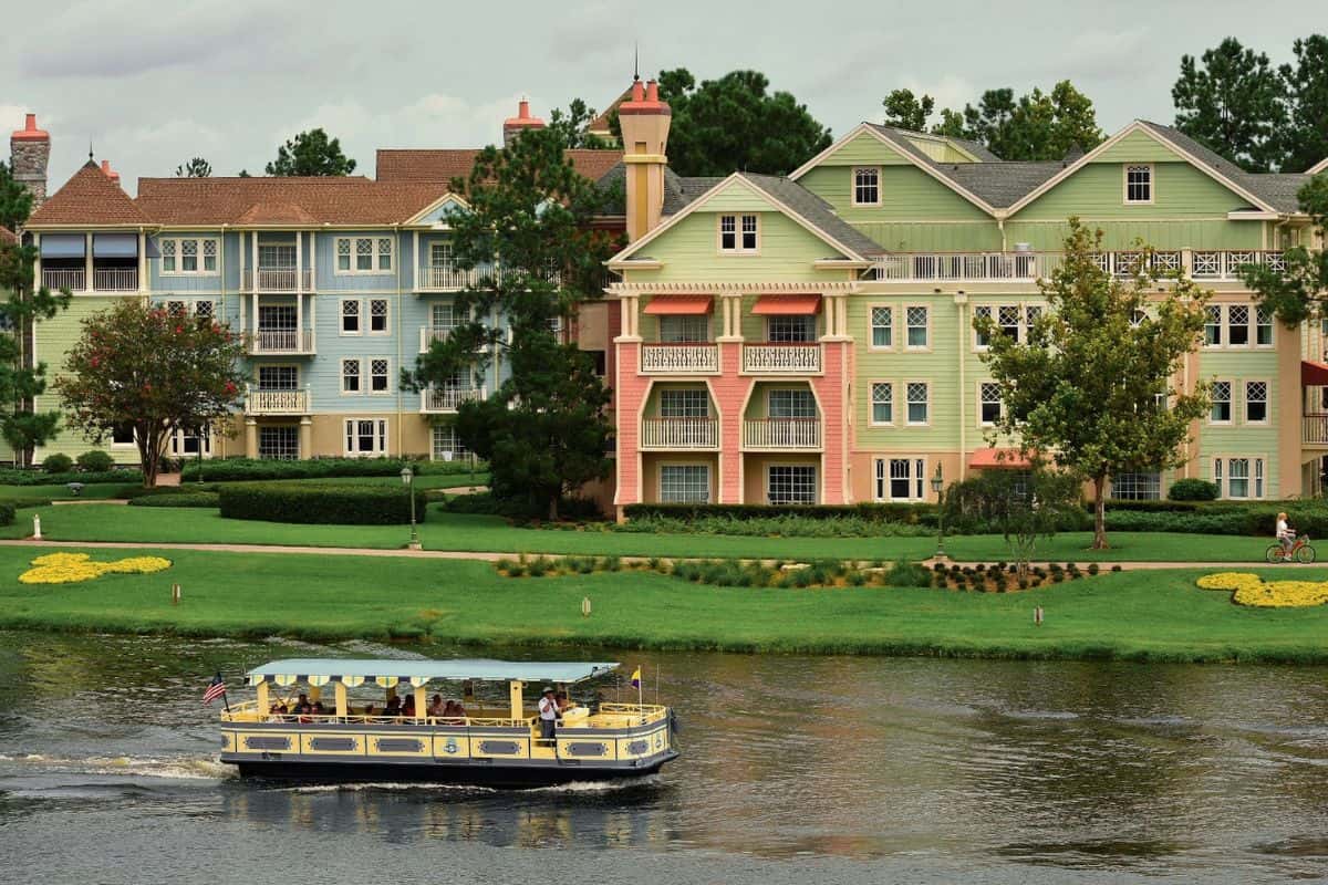 People riding the Water Taxi at Disney World with colorful buildings in the background