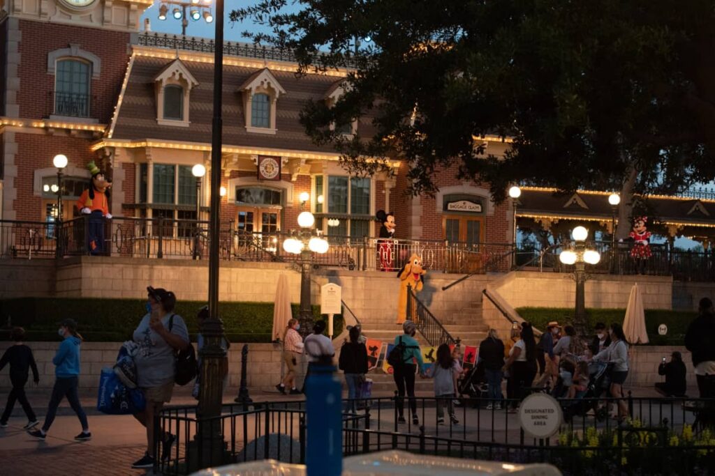Costumed characters waving goodbye to visitors during closing hours at Disneyland