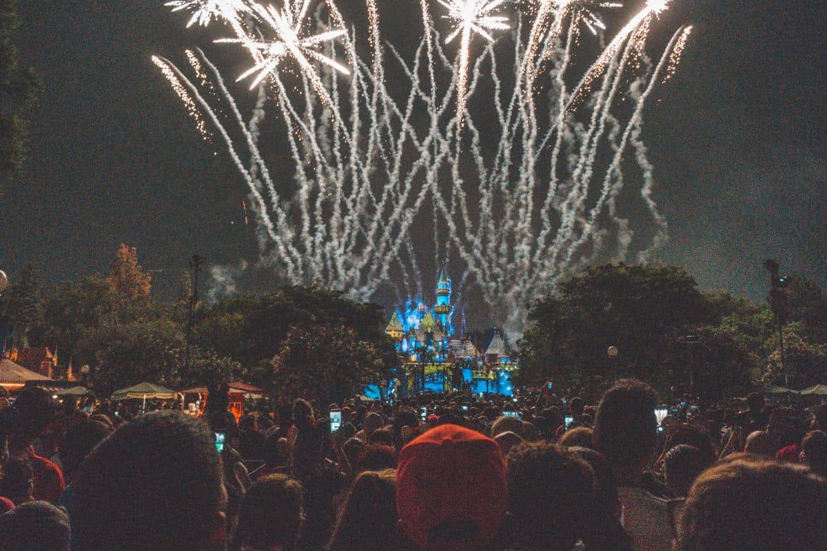 A crowd of people watching a fireworks show at Disneyland