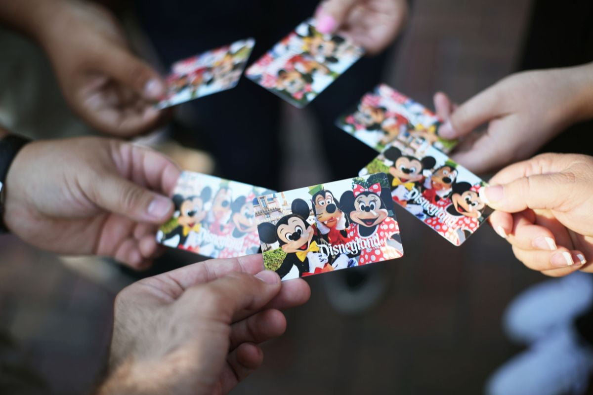 Multiple people in a circle holding Disneyland passes