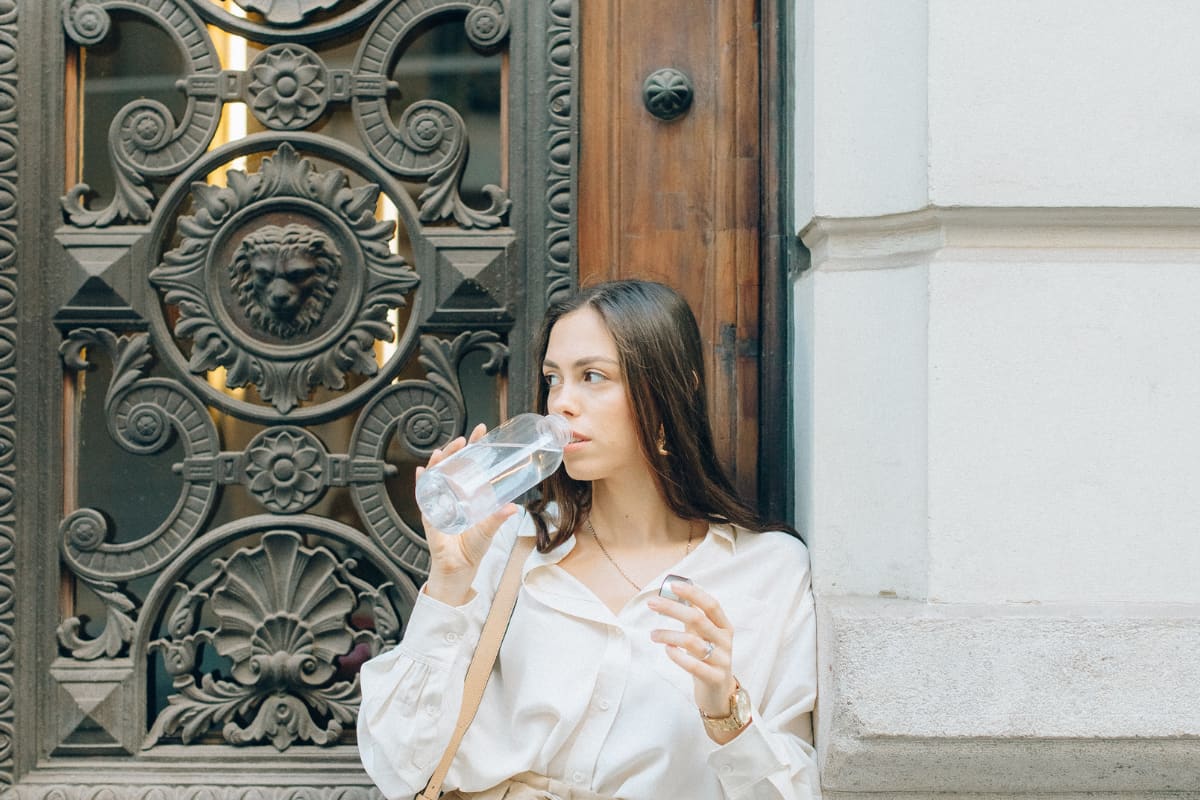 Woman drinking from a clear water bottle