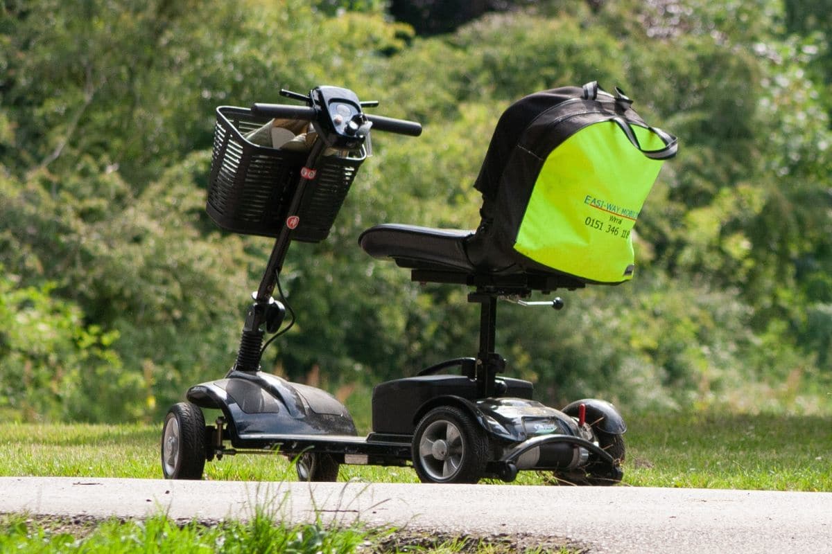 An empty Electric Conveyance Vehicle in a park with a lot of trees