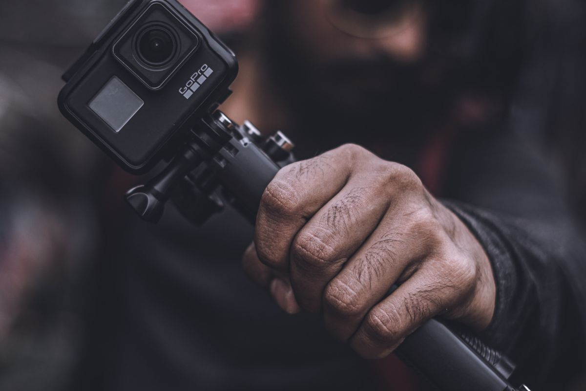 Person holding a GoPro handle with a GoPro mounted on top