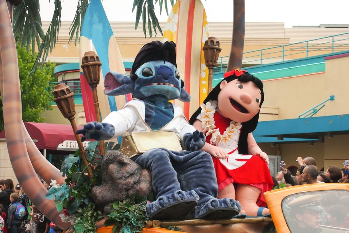 People in Lilo and Stitch costumes riding a float during a parade