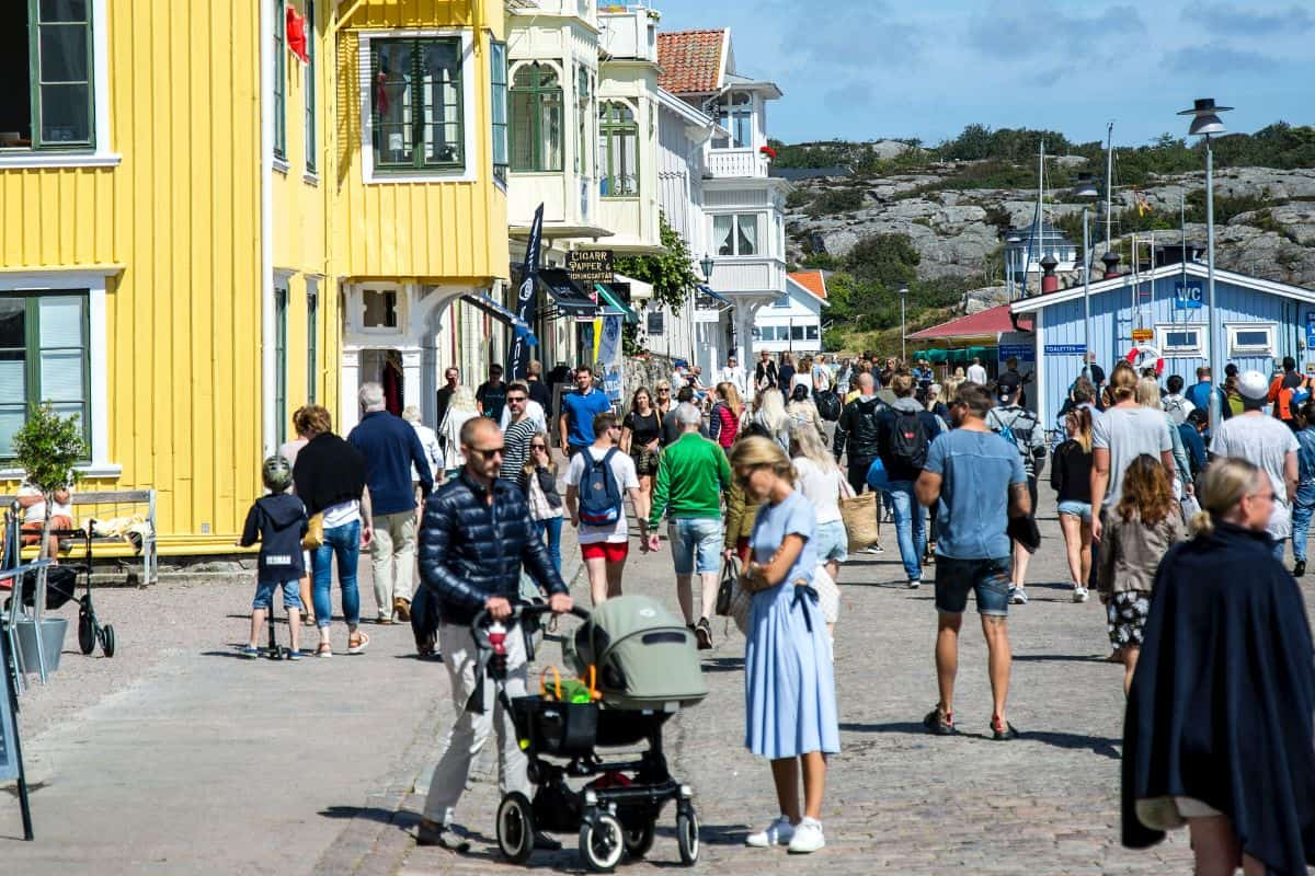 Man pushing a stroller in a crowded outdoor space