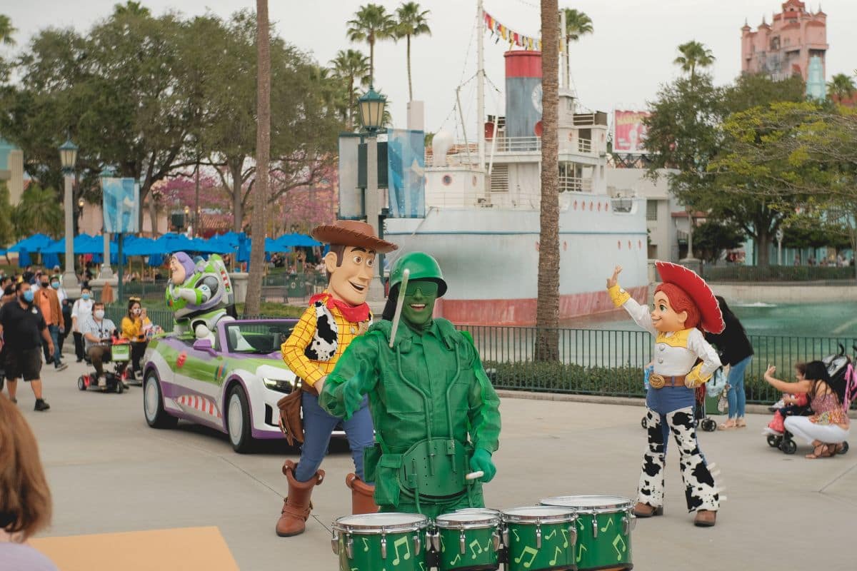 People in costumes based on Toy Story characters performing at a parade