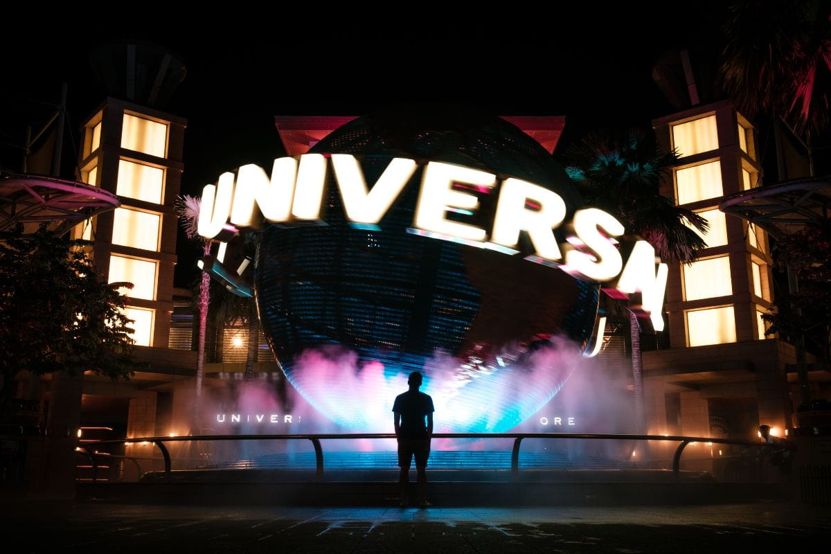 Man standing in front of the Universal Globe at night