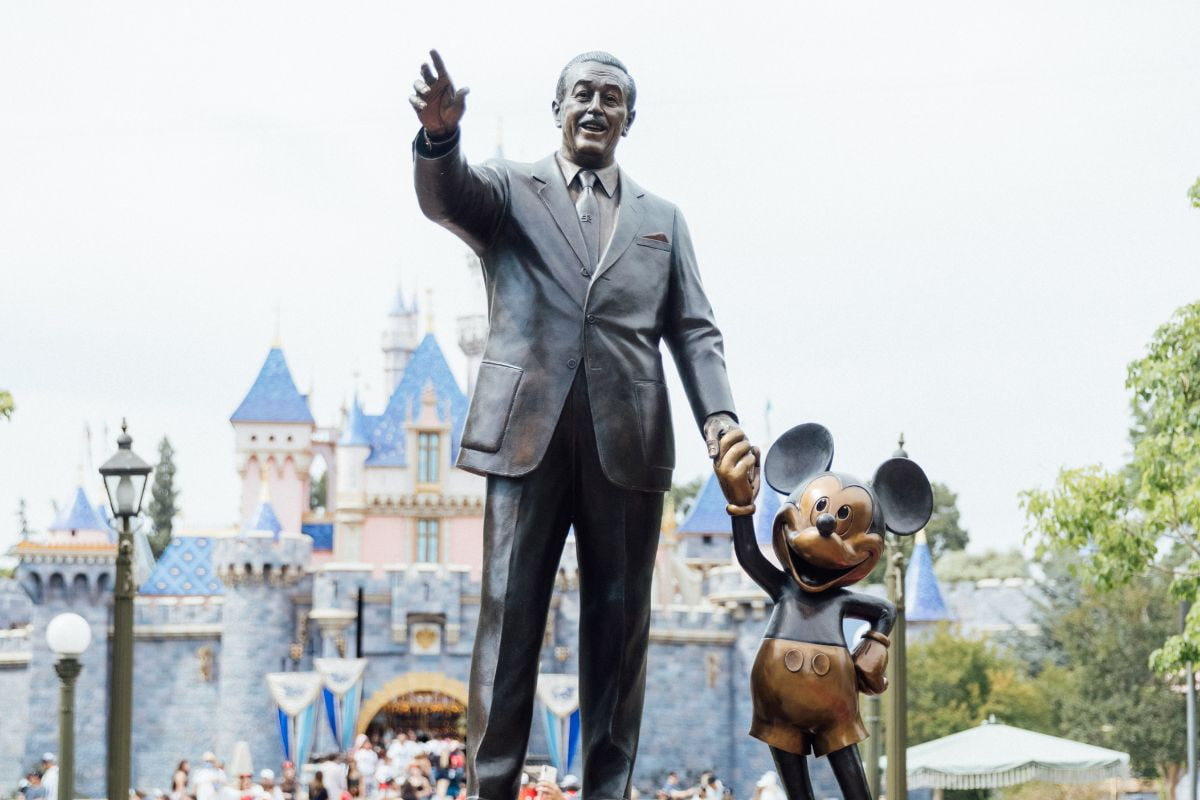 Statue of Walt Disney and Mickey Mouse in front of Sleeping Beauty's Castle