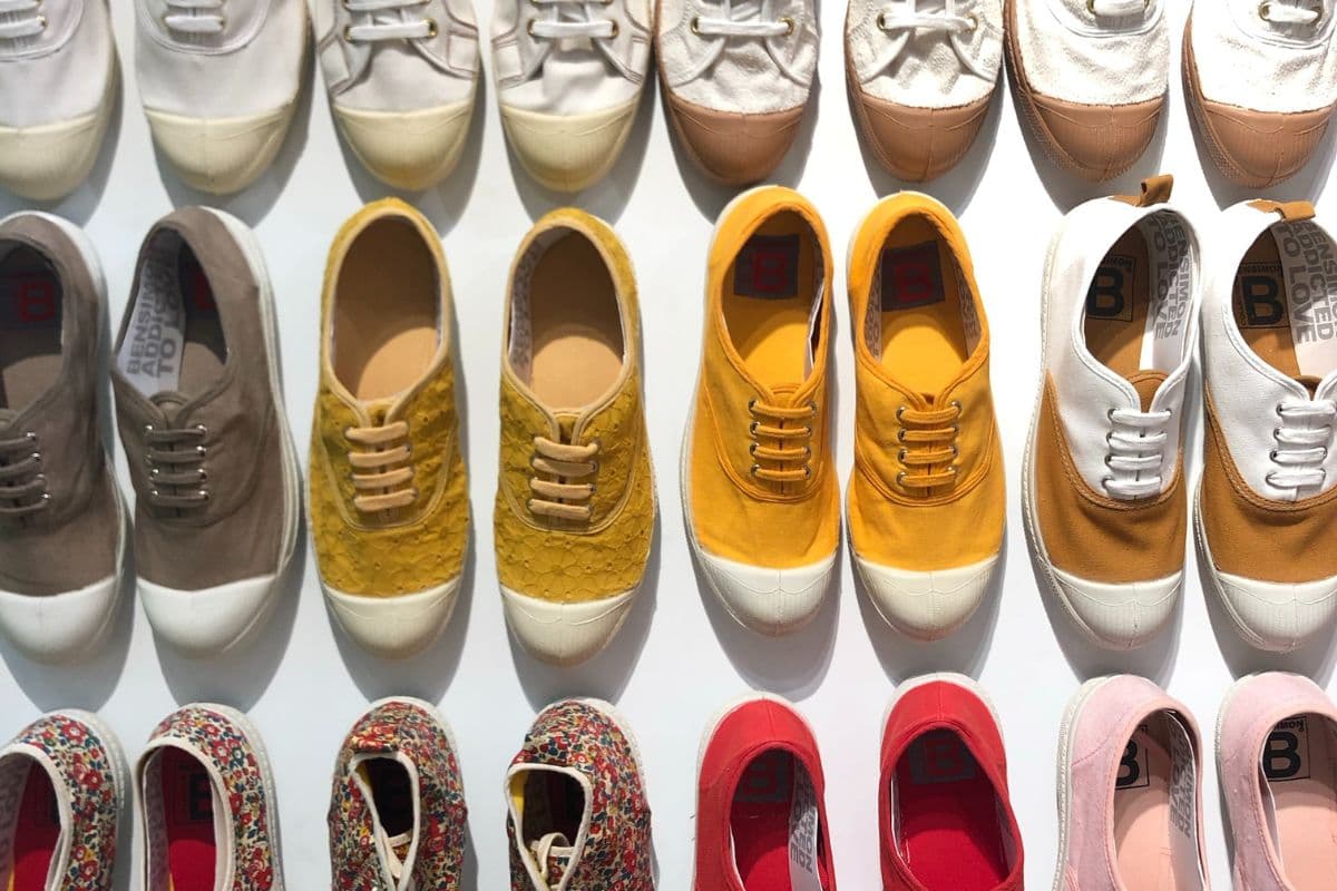 Multiple different colored sneakers on a white floor