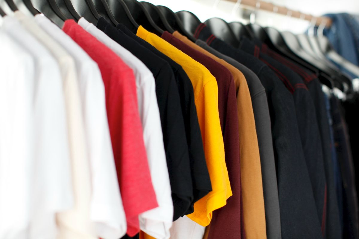 Multiple t-shirts with different colors hanging on a rack