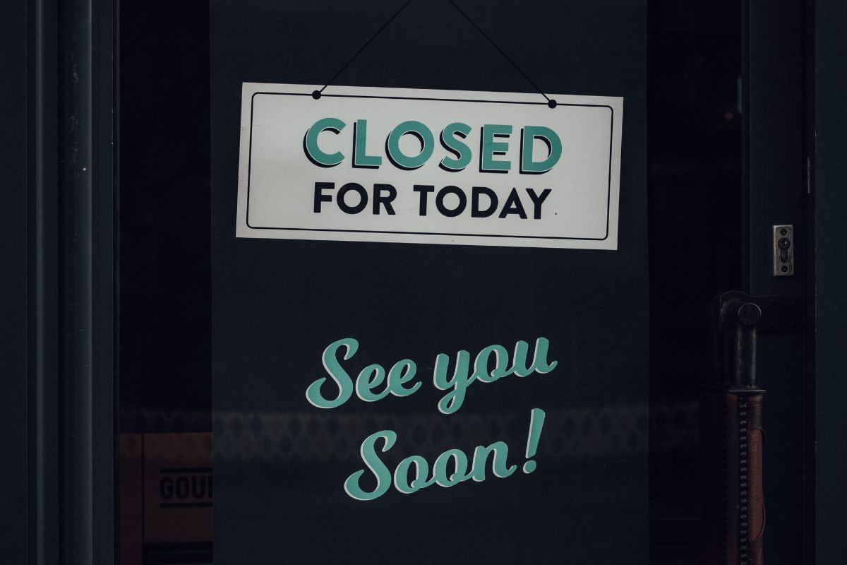 Closed sign hanging on a glass door
