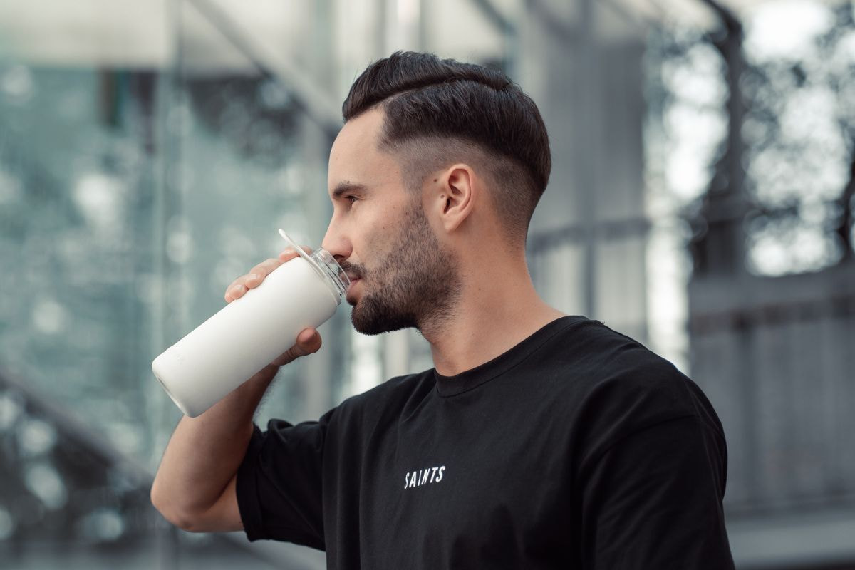 Man drinking from a white water bottle