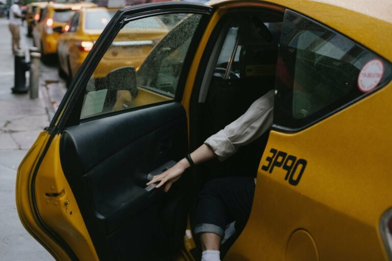 Person getting inside and closing the door of a taxi