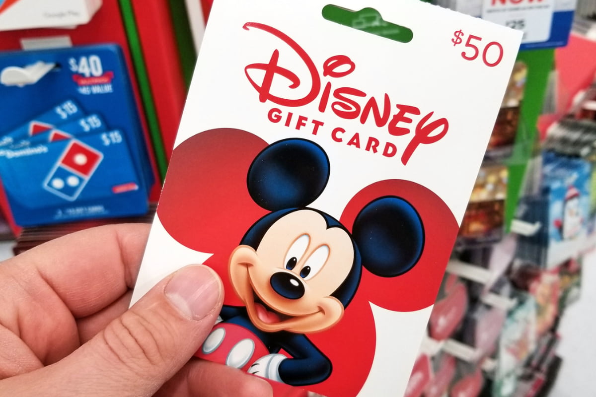 Close up of a person's hand holding a Disney gift card with Mickey's image
