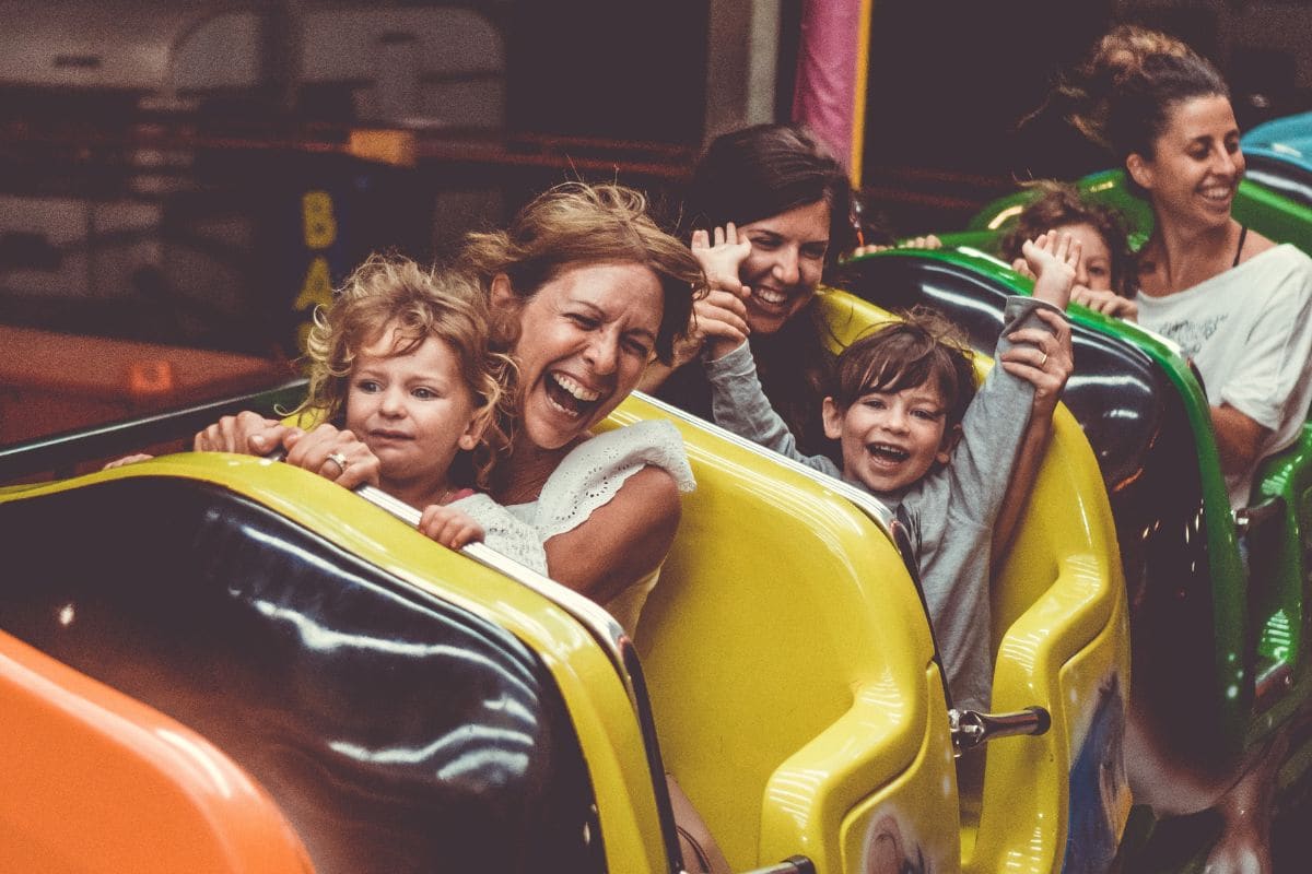 Children with accompanying adults on a theme park ride