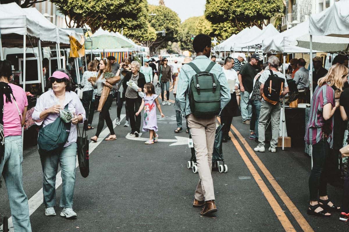 Man wearing a backpack walking through a crowded area
