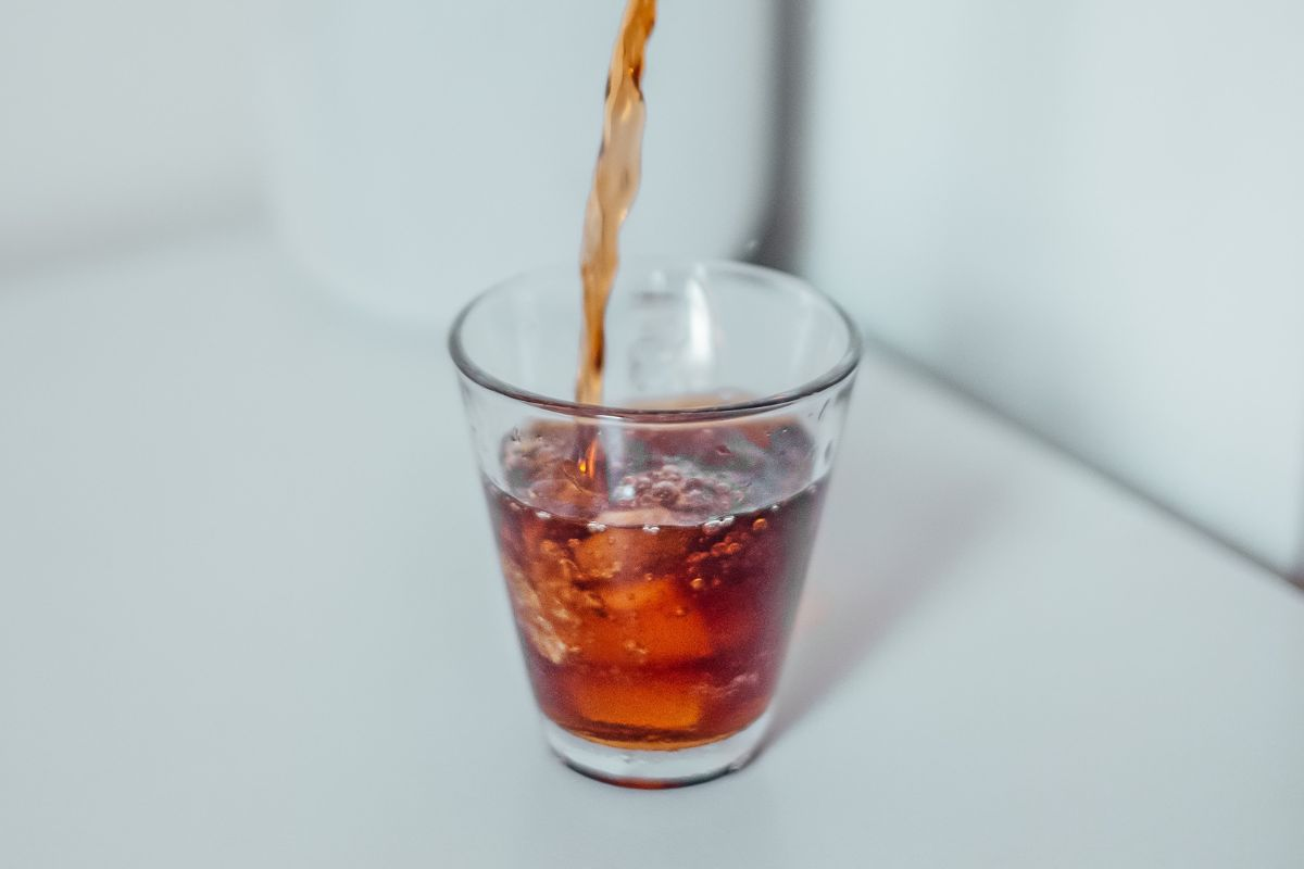 Soda being poured into a glass on a table