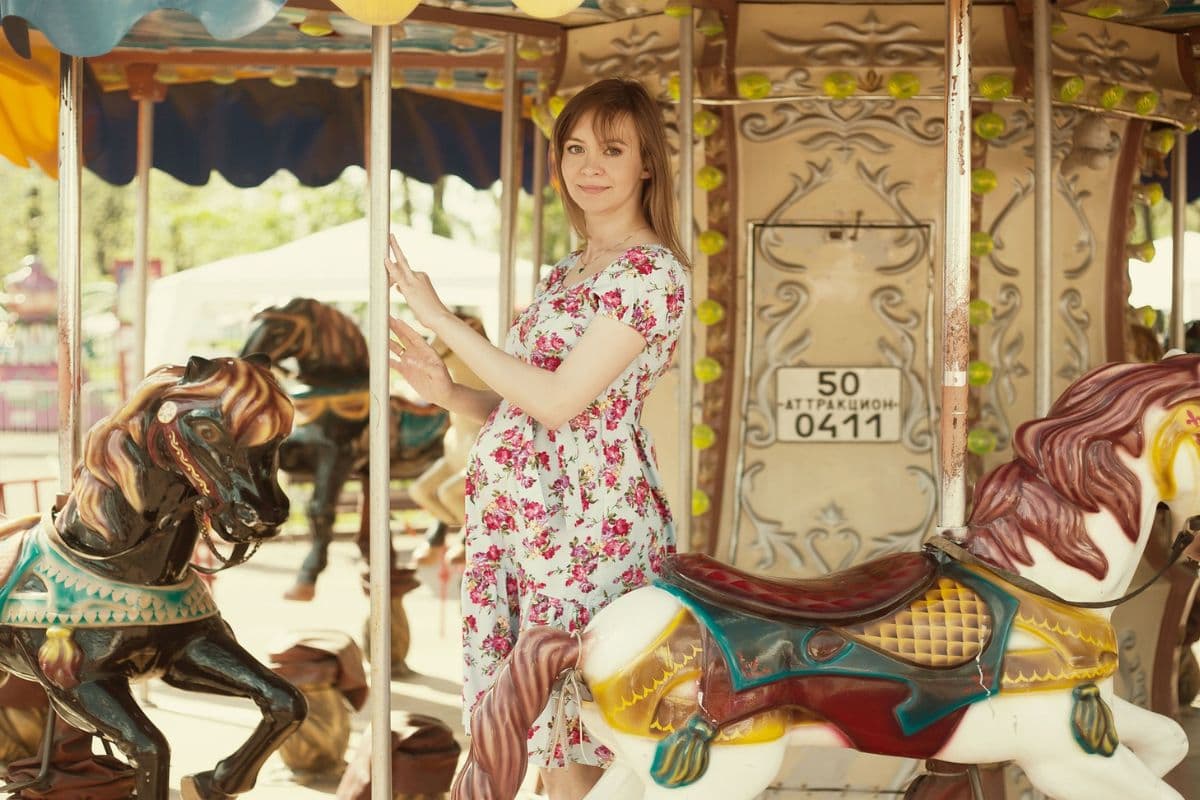 Pregnant woman on a carousel at a theme park