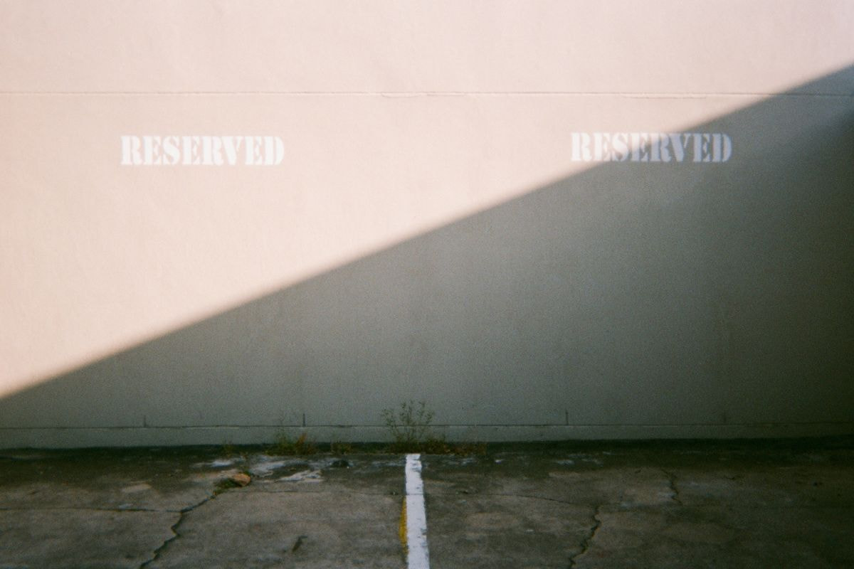 Reserved signs painted on a white concrete wall