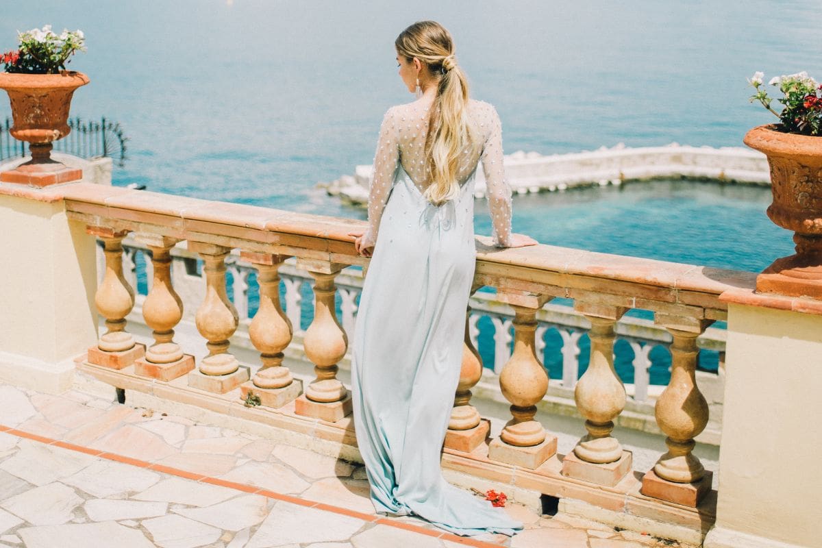 Woman wearing a very long blue dress that is touching the ground