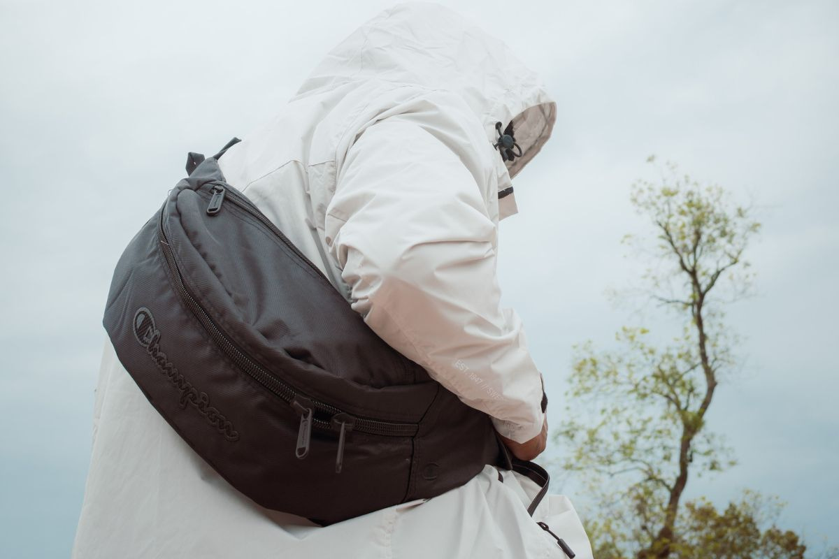 Person in a white jacket wearing a black fanny pack