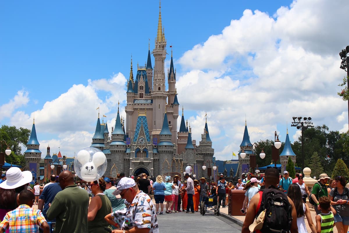 People are walking in front of Cinderella Castle in Magic Kingdom.