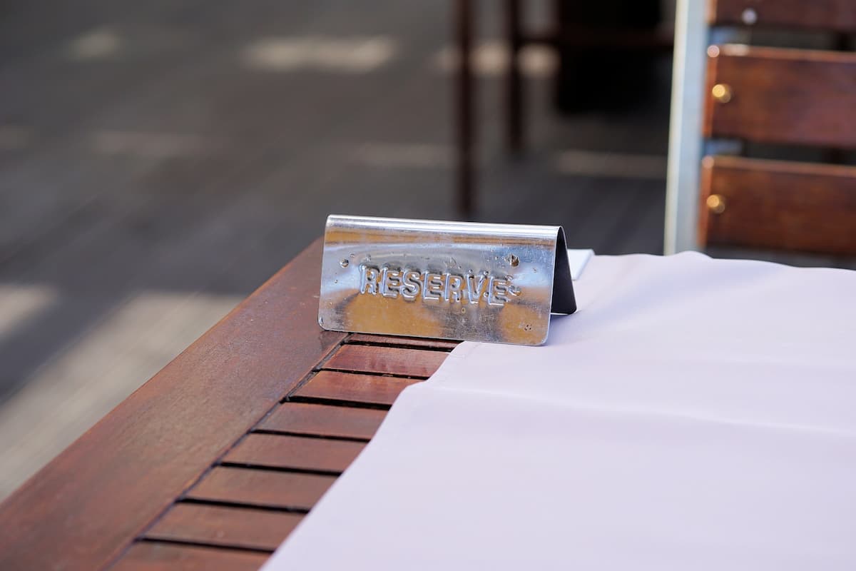 A reserved sign is on the wooden table. 