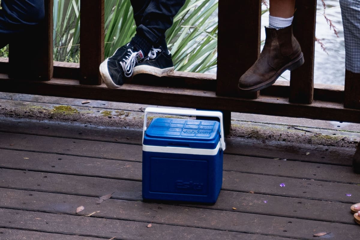 Small blue cooler on a wooden floor