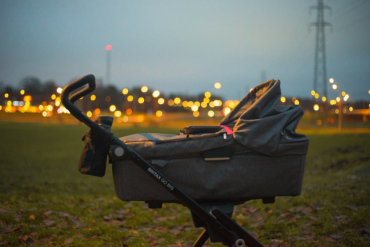 A gray stroller on the grass during sunset. 
