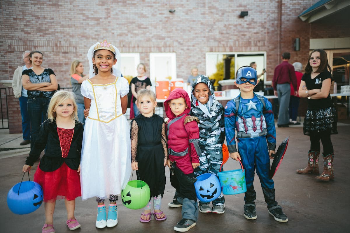 Children in Halloween costumes stand together.