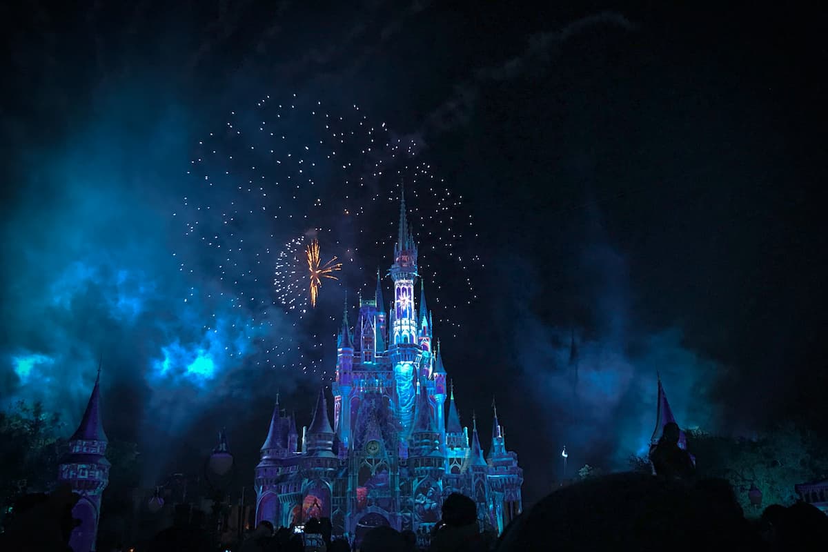 Cinderella Castle at night with fireworks in the sky.