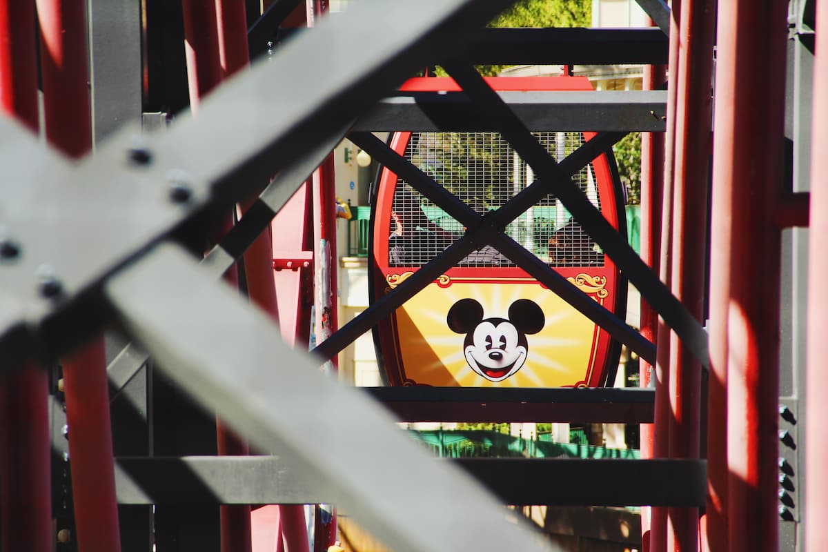 A photo of a Disney Ferris wheel cabin through the metal fence. 