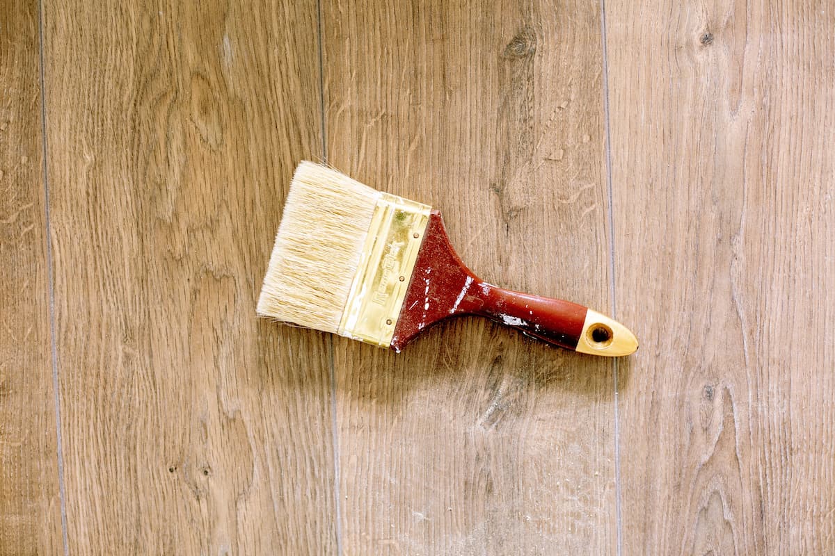 Close-up photo of a paintbrush on a wooden surface. 