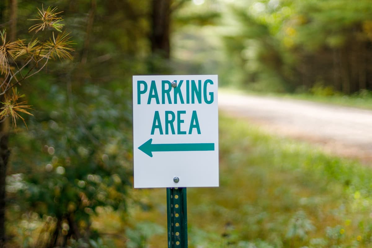 A parking area sign with a blurred background. 