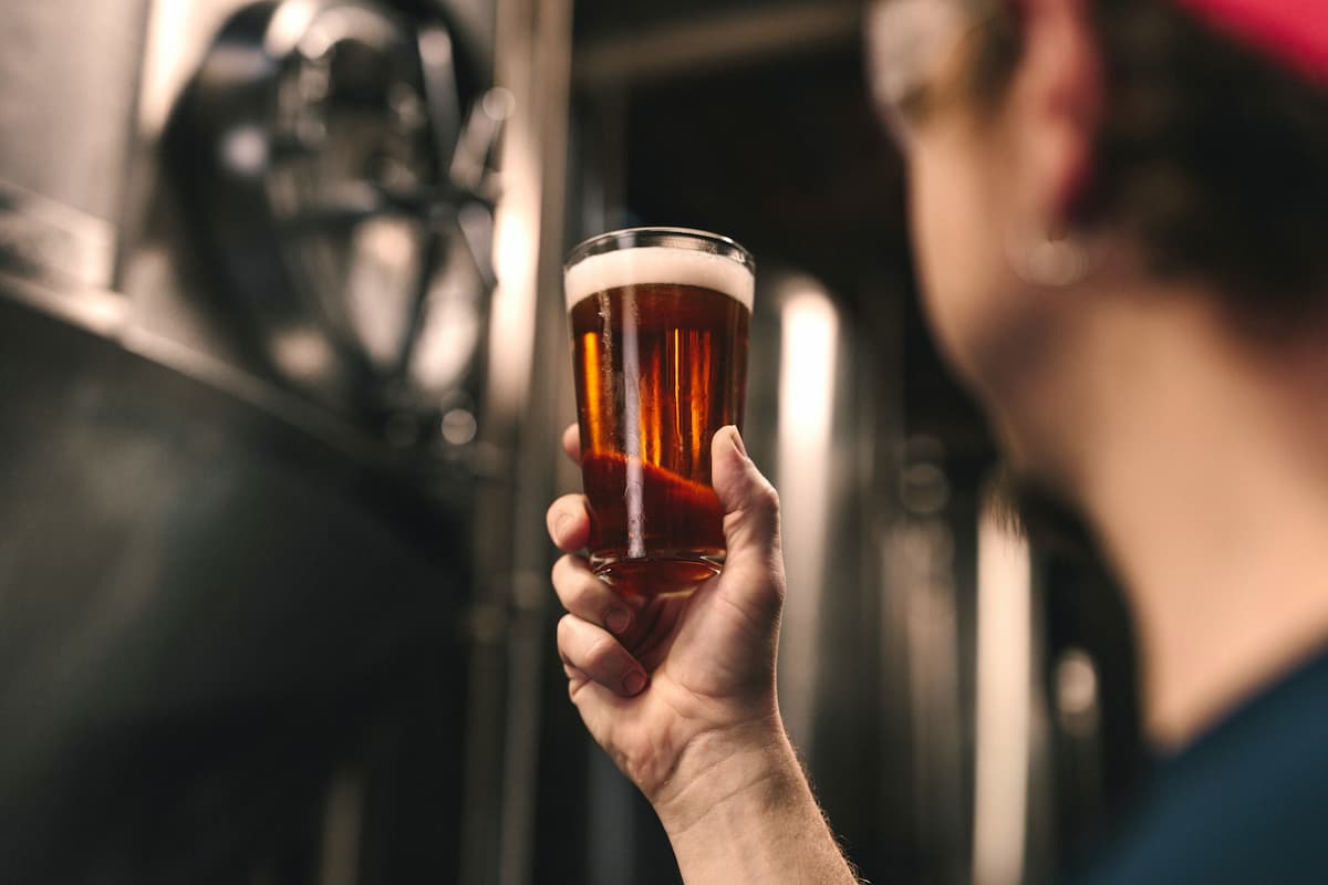 A man holding a glass of beer. 