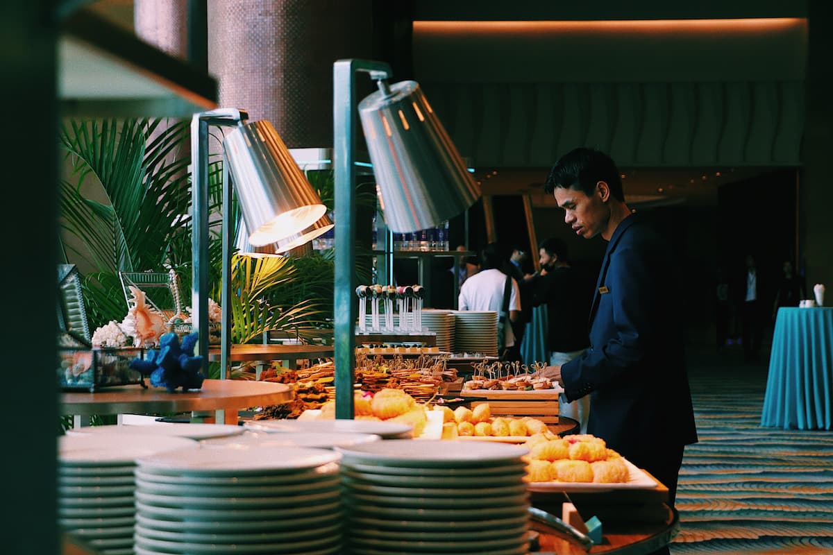 Man picking some food at the buffet table.