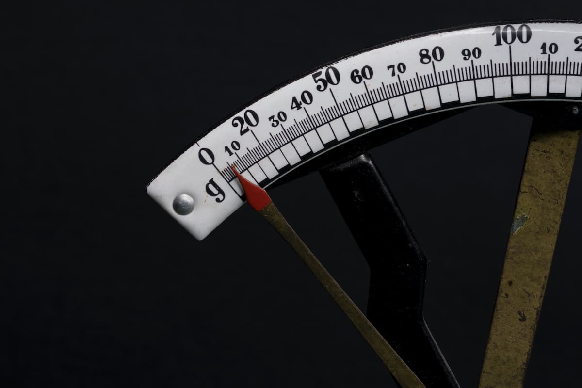 Close-up photo of an old weighing scale on a black background.