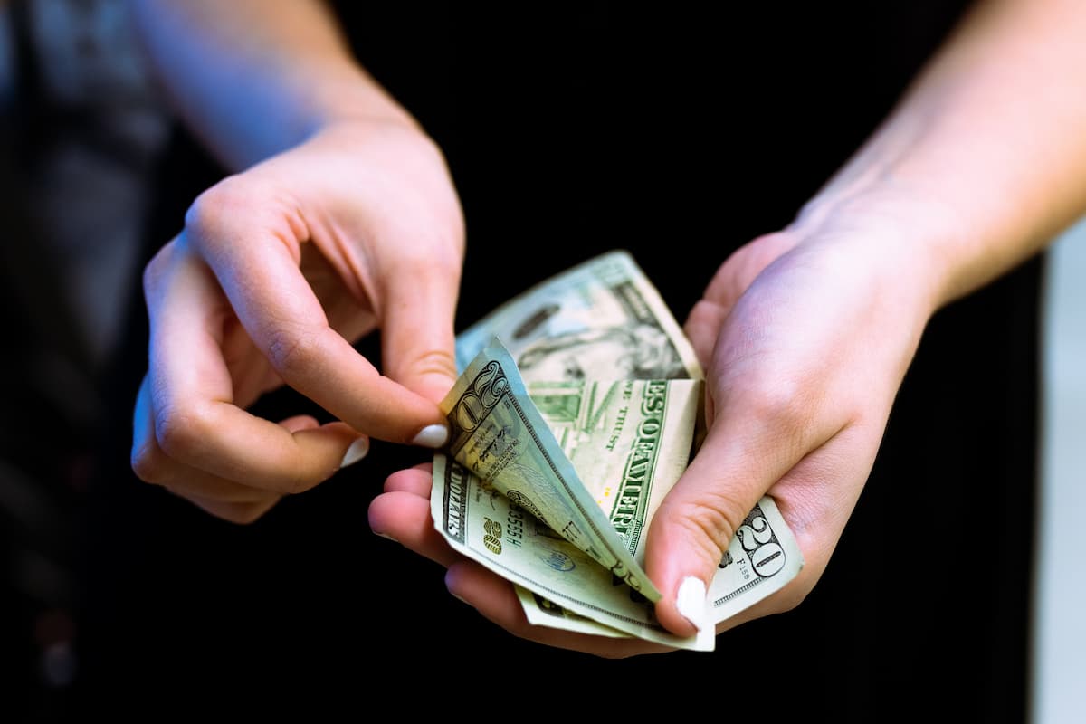 Close-up photo of a person's hand holding money. 