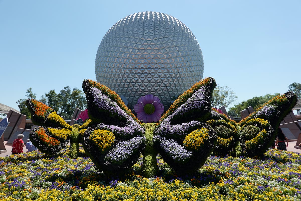 Butterfly topiaries surround the Spaceship Earth.